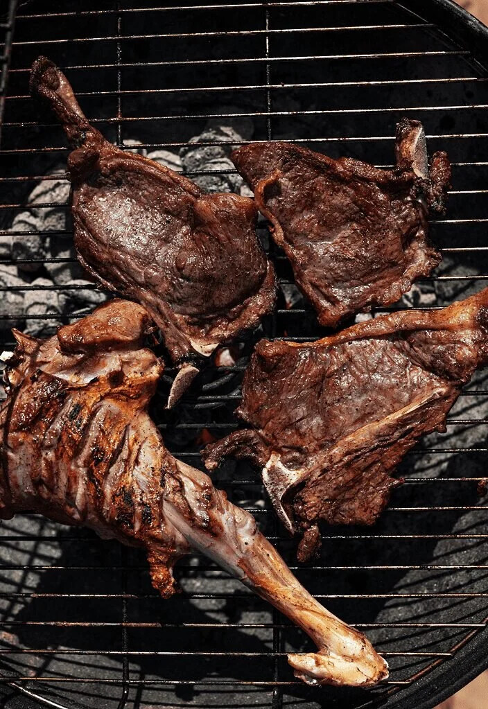 Bone-in goat roasting slowly over glowing charcoal for Nyama Choma